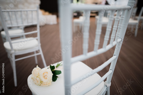 Bridal bouquet on white chair, wedding decoration.