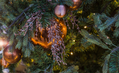 Christmas tree closeup. Golden balls and illuminated garland with flashlights.