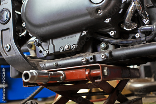 Cropped close up shot of beautiful and custom made motorcycle in the workshop photo