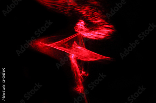 Red abstract on black background. Play with light. Abstraction. Girl. Dance. Wallpaper