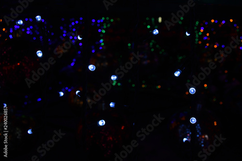 Bright Christmas lights garlands on a black background.