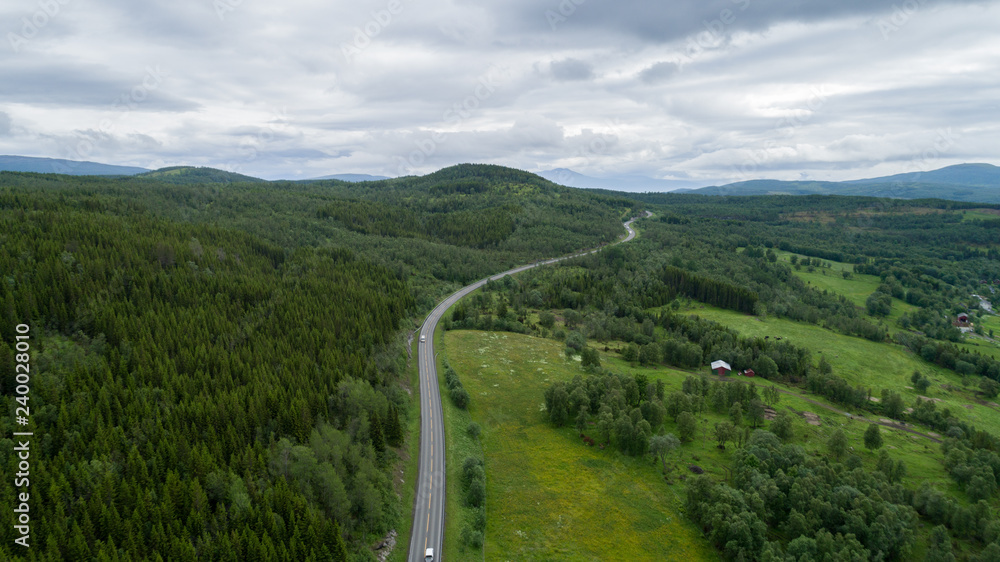 Aerial view of road through countryside, forest and cultivated fields