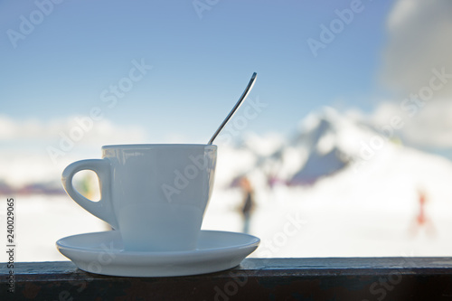 A cup of coffee on the background of snowy mountains © Georgii