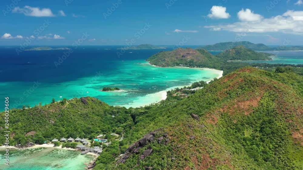 Aerial view of tropical paradise beach with white sand and turquoise crystal clear waters of Indian Ocean - Anse Volbert, Praslin Island, Seychelles Aerial view of tropical paradise beach with white sand and turquoise crystal clear waters of Indian Ocean - Anse Volbert, Praslin Island, Seychelles