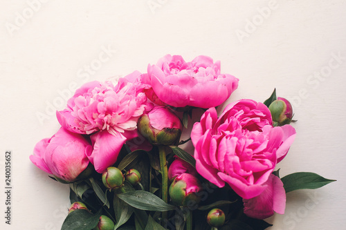 lovely pink peonies on rustic white wooden background top view, space for text. floral greeting card, flat lay. beautiful peony flowers pattern, tender image. happy mothers  day concept photo