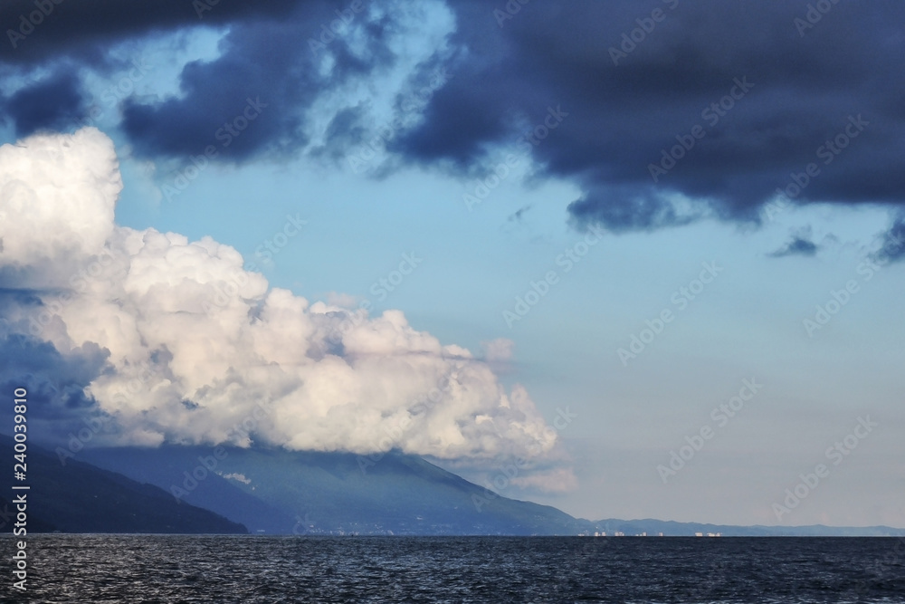 Pyrocumulative and thunderclouds over the mountains and the sea