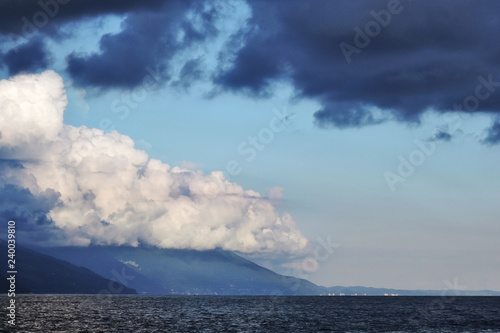 Pyrocumulative and thunderclouds over the mountains and the sea