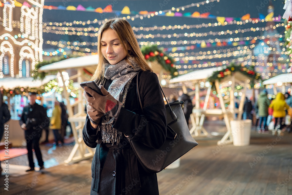 Photo of happy woman with glass and phone in hands in evening for walk Photo of happy woman with glass and phone in hands in evening for walk