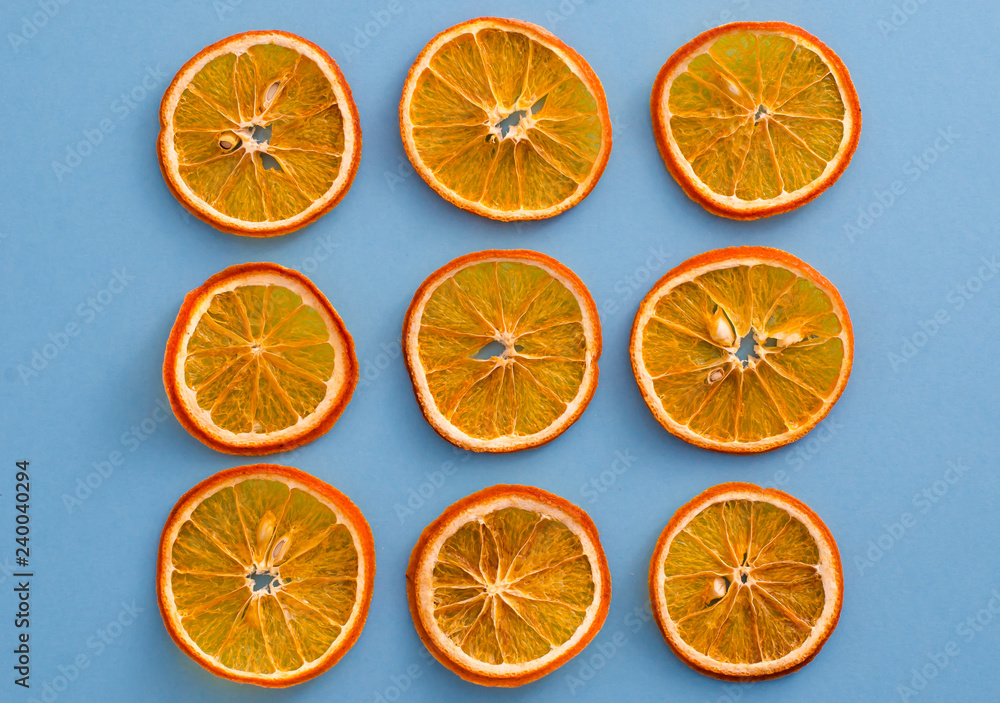 Dried slices oranges citrus fruit on light blue background. Homemade natural aroma decor. Concept of holiday. Marry Christmas. Close up, flat lay, top view Dried slices oranges citrus fruit on light blue background. Homemade natural aroma decor. Concept of holiday. Marry Christmas. Close up, flat lay, top view