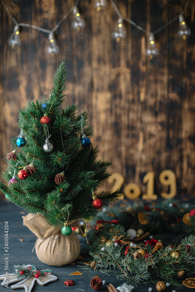 Fototapeta premium Christmas tree with golden numbers 2019 on a wooden background