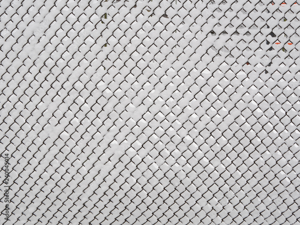 abstract pattern of snowy chain-link fence covered with snow, outdoor winter season shot abstract pattern of snowy chain-link fence covered with snow, outdoor winter season shot