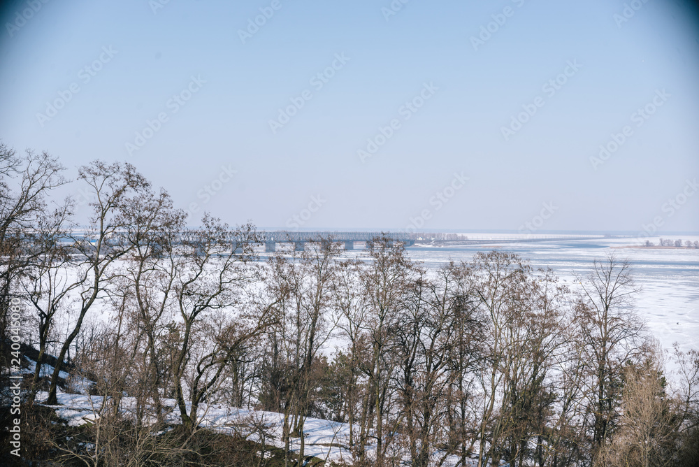 Fototapeta premium A spring sunny day in a snowy park