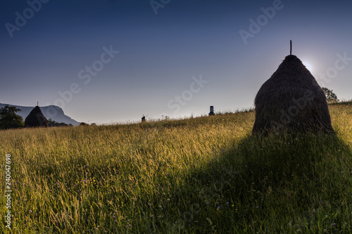 Peaceful scene in sunset about a valley with haystack,  Cavnic, Romania photo