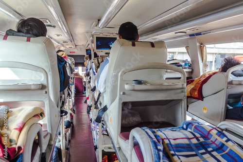 reportage shot of man watching TV in long distance sleeper bus i