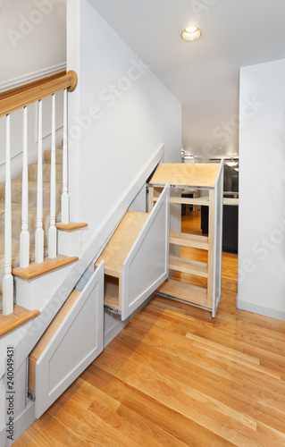 Under-stair pullout cabinets installed in openings with decorative fronts attached (but no handles) photo