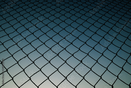 Old metal mesh against the evening sky. Abstract background