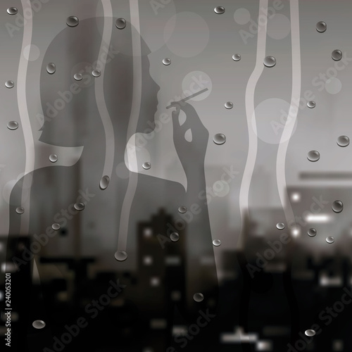 Silhouette of a smoking girl in the window with raindrops on the background of the cityscaperain. drops on glass with blurry background night city view