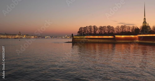 Ioannovskiy bridge and Peter and Paul Fortress at sunset, night colors, trees, river, boats, reflection on the water, pink sky, mirror, golden spike, night illumination, photo