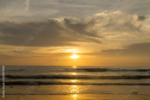 Colorful ocean beach sunset with a few clouds