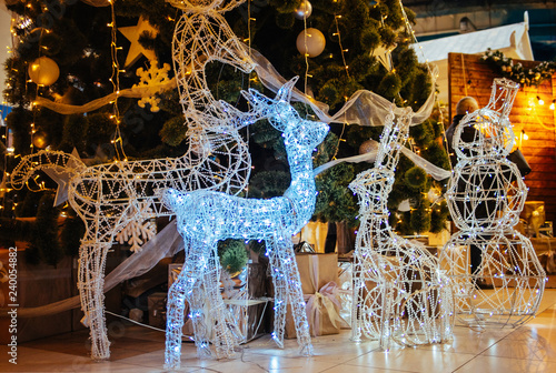 Christmas led illuminated deer sculpture on new year tree background