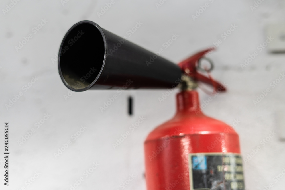 Red fire extinguisher on white wall background, ready to use Red fire extinguisher on white wall background, ready to use