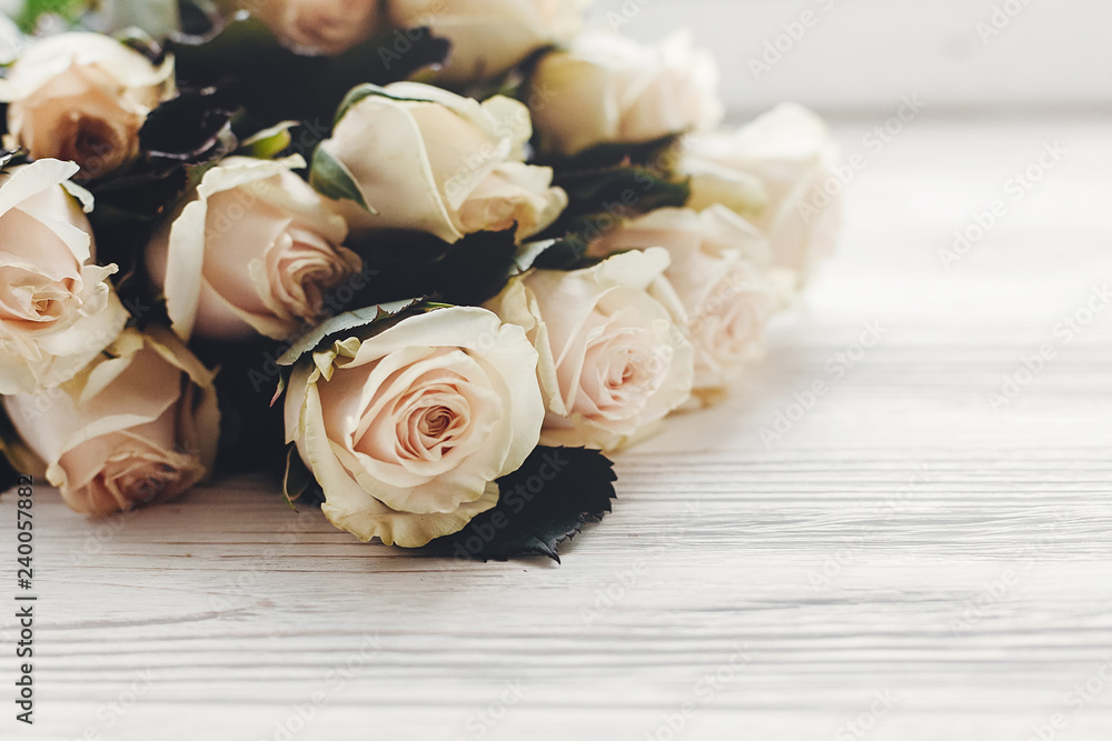 White roses on wooden background, space for text. Floral greeting card mockup. Wedding invitation or happy mother day concept. Bouquet of white flowers. hello spring White roses on wooden background, space for text. Floral greeting card mockup. Wedding invitation or happy mother day concept. Bouquet of white flowers. hello spring
