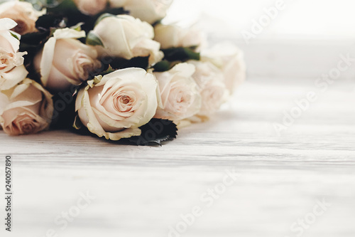 Floral greeting card mockup. White roses on wooden background  space for text. Wedding invitation or happy mother day or valentines concept. Bouquet of white flowers
