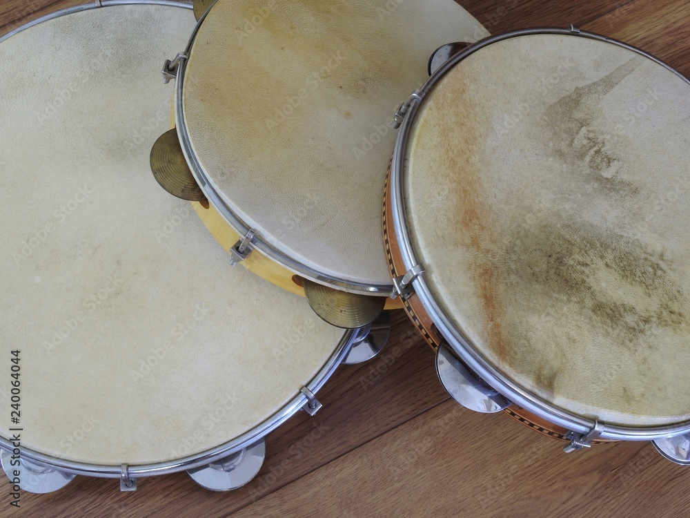 Obraz premium Close-up of three pandeiros (tambourines), a Brazilian musical percussion instrument, on a wooden surface. It is widely used to accompany samba and choro, two popular Brazilian rhythms.