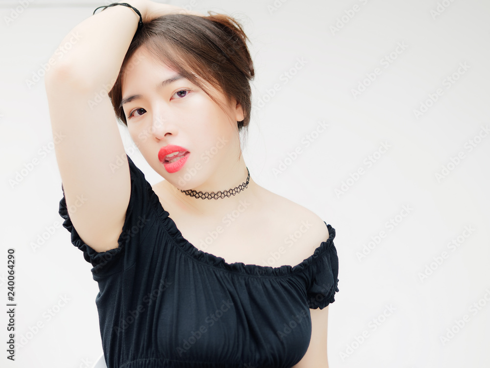 Portrait of beautiful Chinese young girl wearing black tube dress sitting  with white wall background. Posing with hands on head and stay cool. Stock  Photo | Adobe Stock