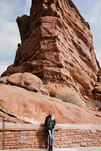 Young Beautiful Modern Caucasian Woman Smiling While Traveling to Red Rocks Park in United States Outside in Nature at the State Park with Ancient Stone and Blue Sky Background