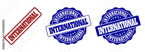 INTERNATIONAL scratched stamp seals in red and blue colors. Vector INTERNATIONAL labels with draft surface. Graphic elements are rounded rectangles, rosettes, circles and text labels.