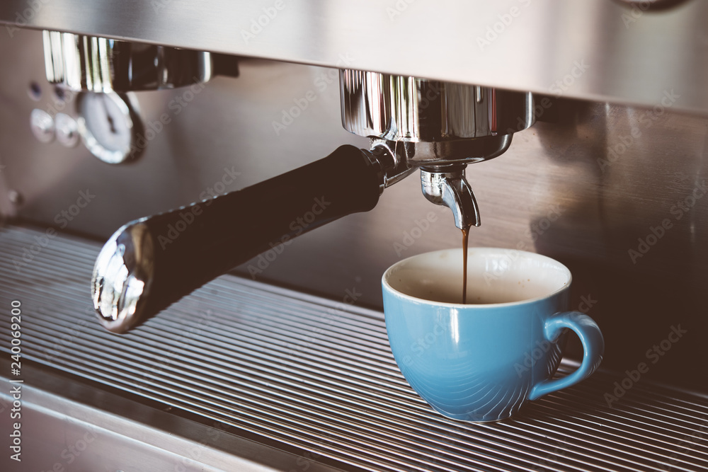Espresso machine making coffee with blue cup in pub, bar, restaurant Espresso machine making coffee with blue cup in pub, bar, restaurant