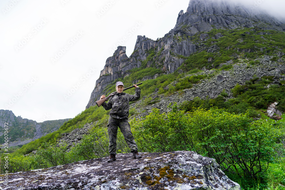 Travelers in the mountains Duse Alin Russian Far East Khabarovsk region. Girl with gun on mountain lake by the name of the Bear Ridge Duse Alin Russian Far East Khabarovsk region.