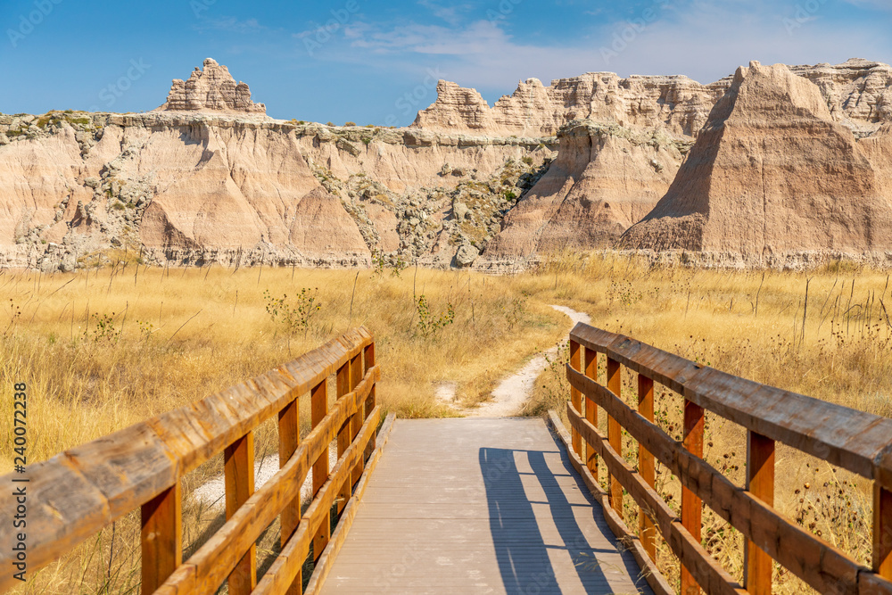 Panoramic View of Badlands Geological Features with Bridge in foreground