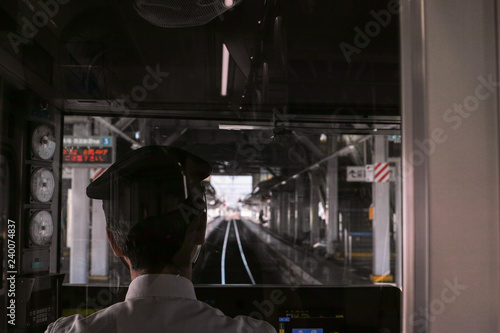 Rear view of a train driver pulling into a station