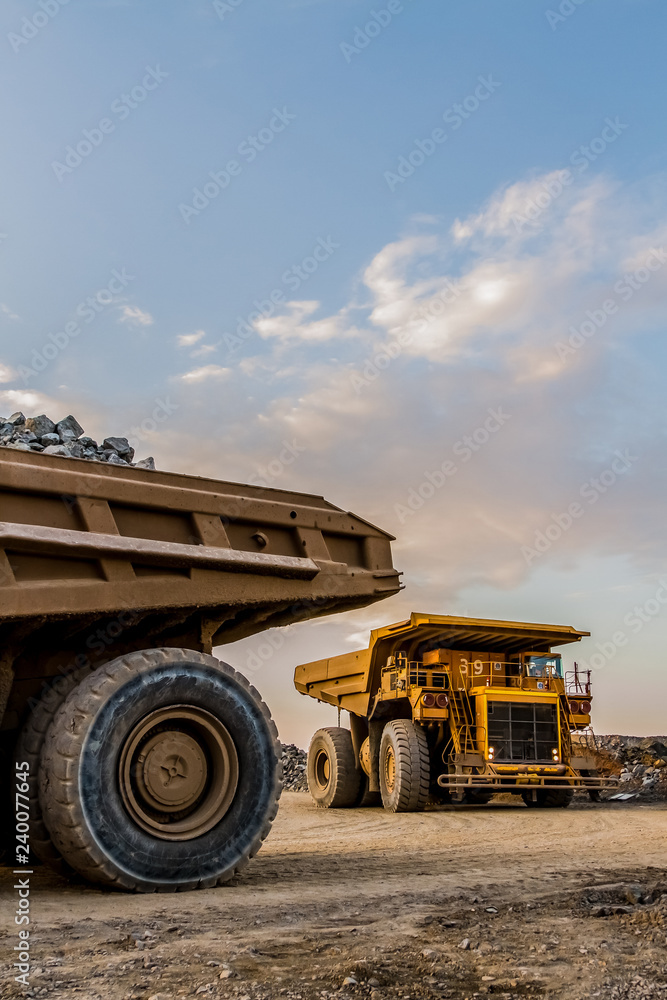 Obraz premium Mining dump trucks transporting Platinum ore for processing
