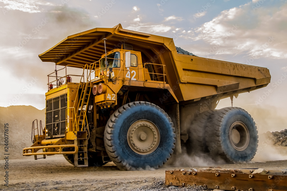 Obraz premium Mining dump trucks transporting Platinum ore for processing