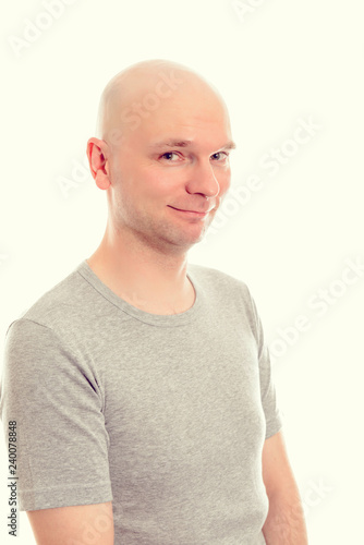 young man with bald head  is smiling in to the camera