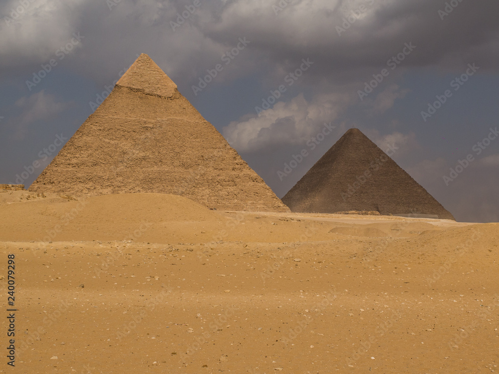 Two of the great pyramids with one in the sun and one in shadow