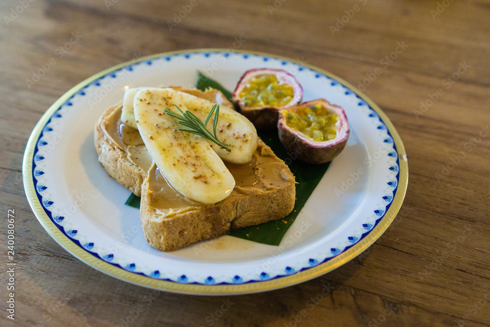 peanut butter banana toast and fruit rosemary on a plate peanut butter banana toast and fruit rosemary on a plate
