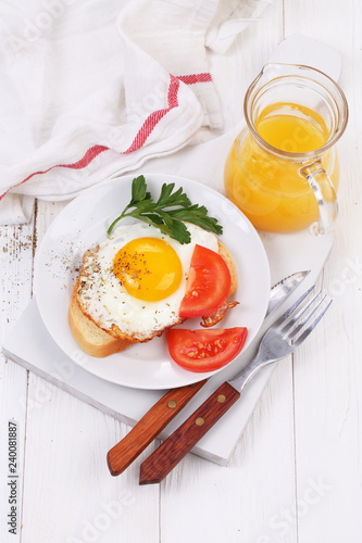 fried eggs on a piece of white bread and orange juice