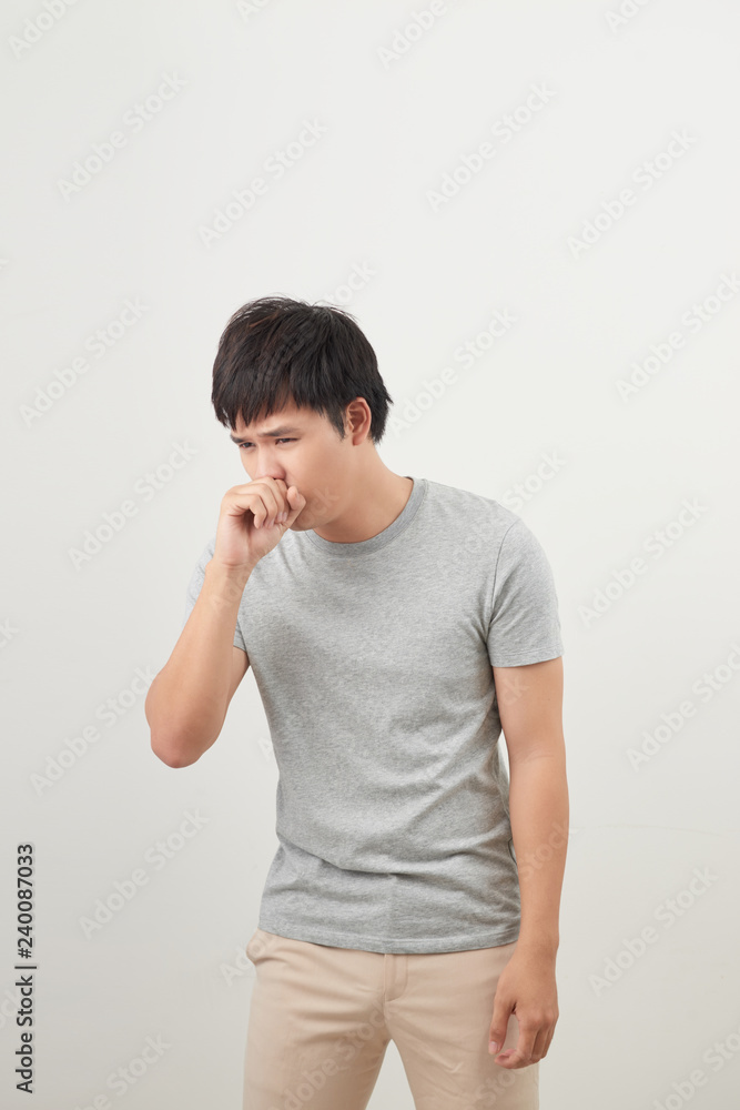 handsome man coughing into his fist, isolated on a white background