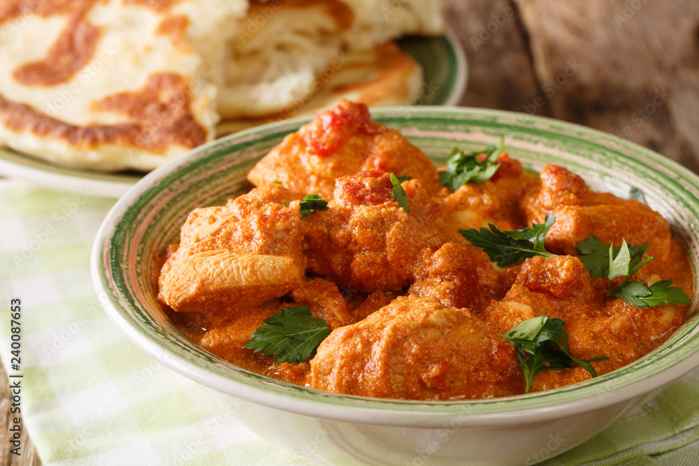 Indian food spicy karhai chicken in tomato sauce close up and naan on the table. horizontal Indian food spicy karhai chicken in tomato sauce close up and naan on the table. horizontal