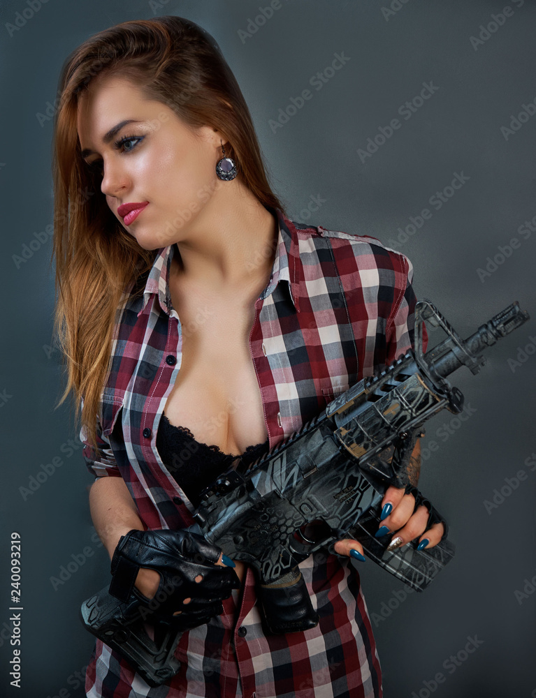 Sexy blonde in a black bra with a gun Stock Photo
