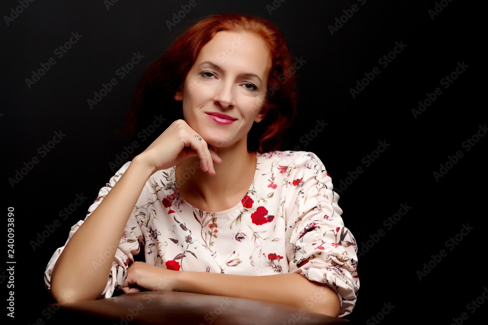 Red-haired young woman in the studio on a black background. Red-haired young woman in the studio on a black background.