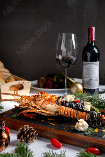 Luxury dinner menu grilled lamb, pasta lobster during Christmas and New year. Decrated with festive elements, wine, bred, red burry. Beautiful classic background with space.