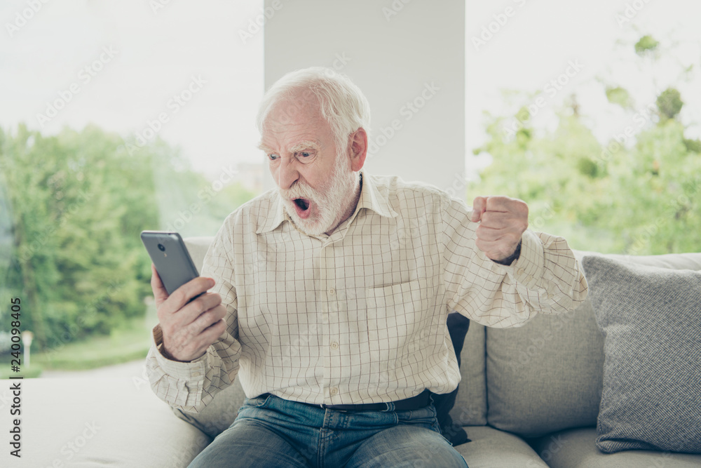 Portrait of mad fury old man wearing checked shirt sitting on di Portrait of mad fury old man wearing checked shirt sitting on di