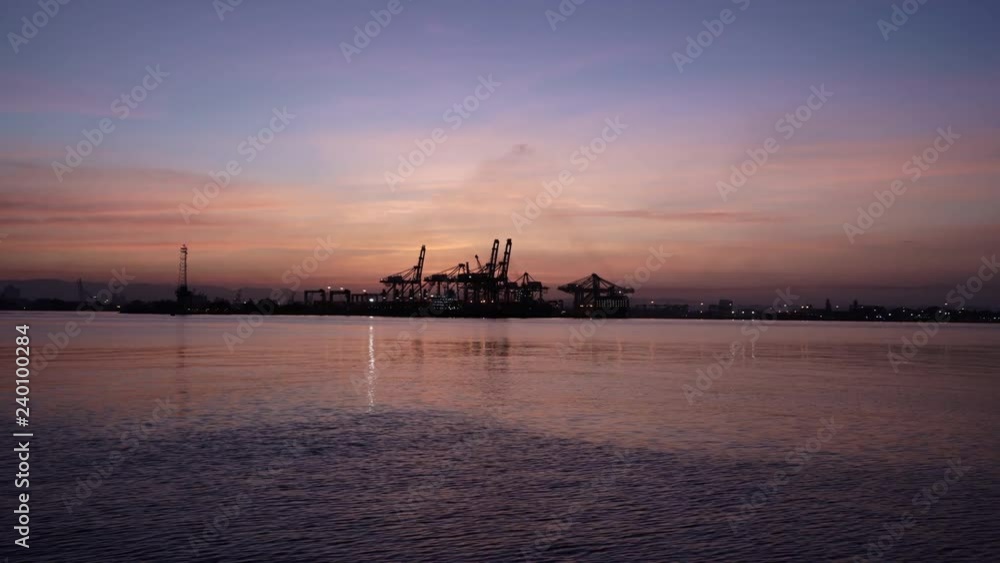 Crane Silhouettes in Maritime Container Port During Sunrise With Boats Crane Silhouettes in Maritime Container Port During Sunrise With Boats