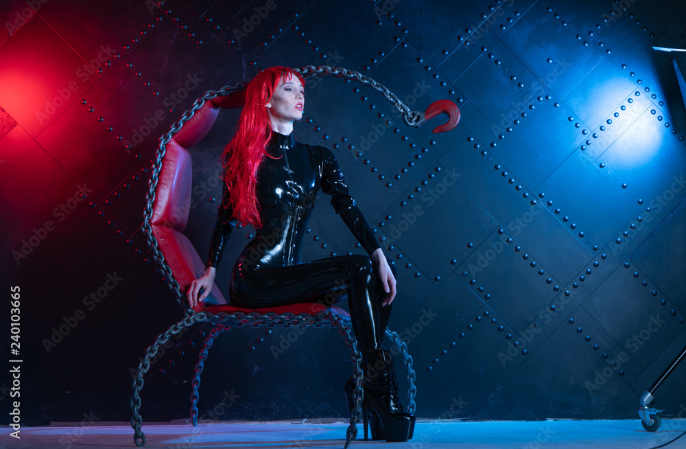 dangerous cruel fetish girl with red hair posing in black bdsm latex clothes at the chair from the chains in the style of sadomasochism Stock Photo | Adobe Stock dangerous cruel fetish girl with red hair posing in black bdsm latex clothes at the chair from the chains in the style of sadomasochism Stock Photo | Adobe Stock