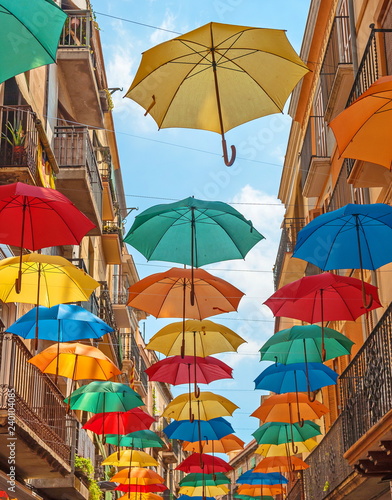 Bright, colorful umbrellas adorn the city street.